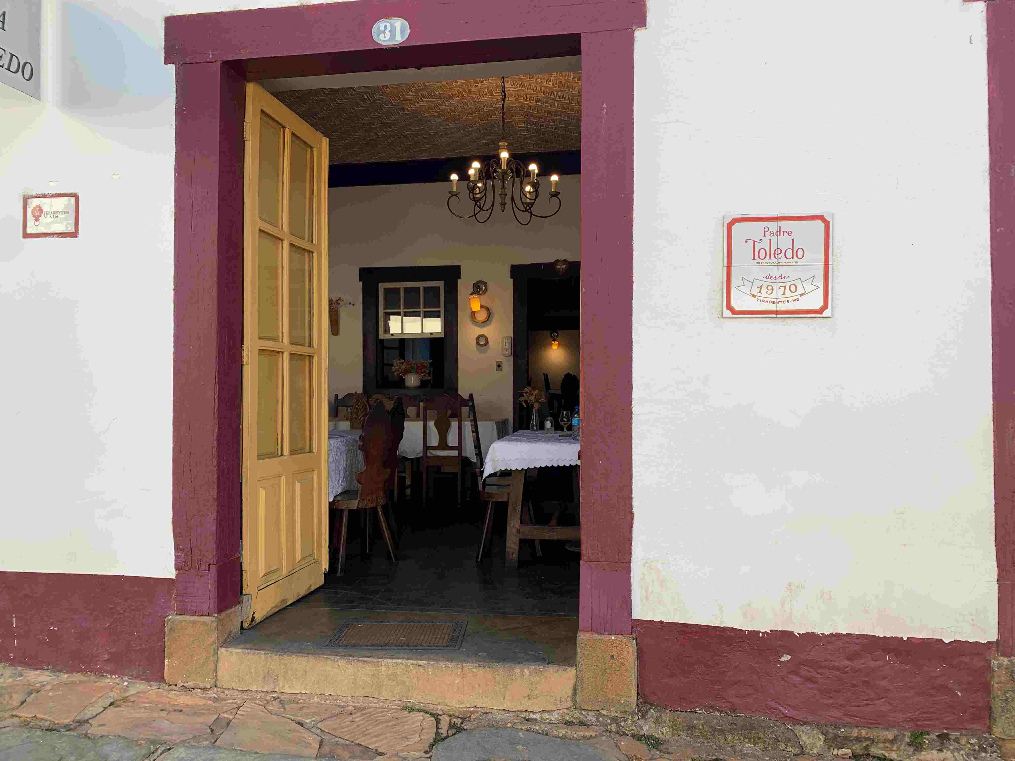 fachada do restaurante Padre Toledo mostrando a porta de entrada com o contorno vermelho