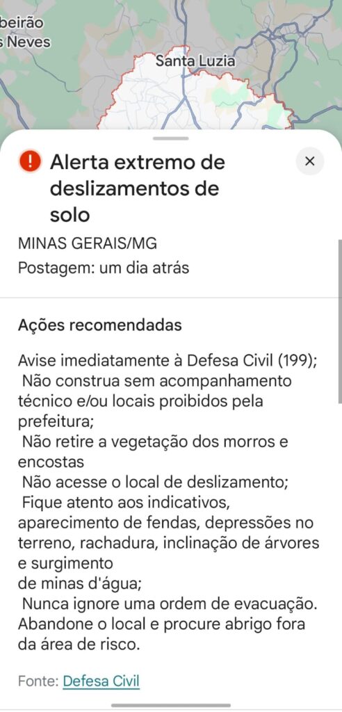 Captura de tela de celular exibindo alerta extremo de deslizamentos de solo em Minas Gerais, com recomendações da Defesa Civil.
